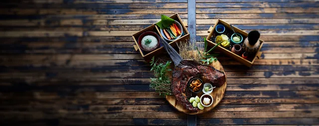 Overhead view of a Kemuri Tatsu-ya meal arranged on a wooden table.